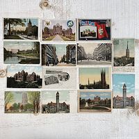 Full spread of all 14 vintage Toronto postcards laid out on a white wooden surface, showing diverse city scenes and historic buildings.