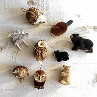 Nine woodland animal ornaments laid out on a white textured surface showing all items in the set.
