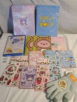 Full lot with Hello Kitty and other branded stationery and stickers laid out on a fabric surface