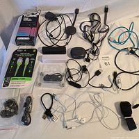 Overview photo of all electronics laid out on a flat surface showing power banks, earphones, various cables, and smartwatch.