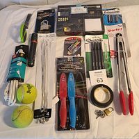 Photo of assorted household items including knives, batteries, markers, tennis balls, flashlight, kitchen tongs etc.