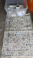 Floor rug with floral paisley design and a lot number card