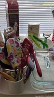 Photo showing hand blender box, oven mitts, kitchen utensils, glass baking dishes and green apple slicer