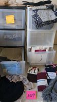 Image showing scarves draped over storage drawers and tights in packaging on top of the bin labeled 109