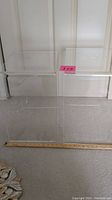 Two clear acrylic cube tables side by side on carpet with ruler at front for scale