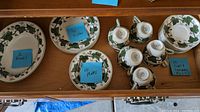 Drawer with one large serving bowl, six dishes, ten small plates, and ten cups and saucers stacked
