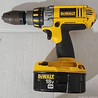 Full side view of the yellow and black DeWalt DC925 cordless drill with 18V battery installed.
