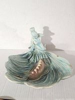 Front angled view of ceramic mermaid ashtray on shell with conch detail, showing wave texture and glaze color.