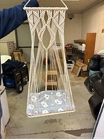 Photo of a cream-colored, handwoven rope kids hammock with macrame design featuring a cushion with polar bear faces.