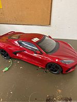 Red New Bright 1:8 scale sports car model with black wheels on the floor in used condition.