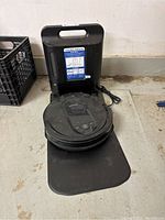 Shark black robot vacuum on black docking station with power cord and instructional label visible.