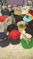 Photo showing 16 assorted baseball and snapback hats with various logos and colors.