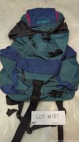 Front and side view of first McKinley hiking backpack, green and blue with logo and straps visible.