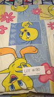 Close-up of folded Tweety Bird fleece blanket showing cartoon print and flower design.