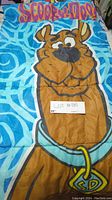 Full view of the sleeping bag laid flat showing Scooby-Doo graphic on blue swirl patterned fabric