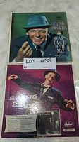 Photo of two Frank Sinatra vinyl record albums: 'Come Dance With Me!' with Sinatra in a blue hat and 'Swing Easy!' with Sinatra dancing on a dark background, showing front covers.
