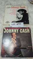 Two Johnny Cash vinyl record albums, 'Now Here's Johnny Cash' and 'The Fabulous Johnny Cash' with wear visible on covers.