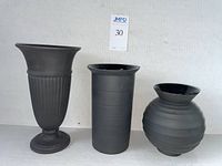 Front view of all three black basalt vases on white surface