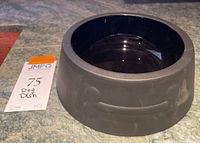 Top view of matte black ceramic dog dish showing glossy black interior and matte exterior with bone embossing.