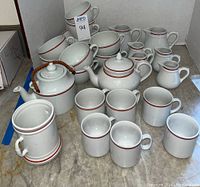 Overview of all porcelain pieces arranged together showing mugs, pots, servers
