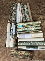 Overview of all wallpaper rolls and fabric border laid out on floor
