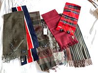Seven men's scarves arranged flat showing patterns and labels