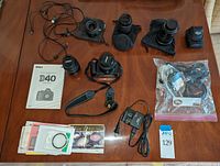 Overhead view of all items including camera body, three lenses, charger, cables, manual and accessories