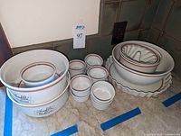 Top-down view of two souffle dishes, six ramekins, tart pan, jello mould and serving bowl on countertop