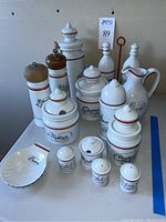 Overview of all porcelain pieces including pitcher, jars, shakers, cruet set, butter dishes and grinders