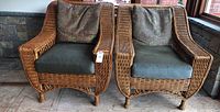 Front view of both wicker armchairs side by side on porch floor