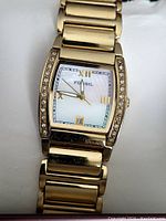 Close-up view of the vintage Fossil wristwatch showing gold-tone bracelet and rhinestone bezel.