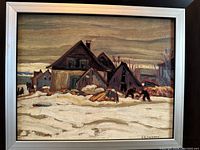 Front view of the framed painting print showing rustic houses in winter landscape with snow and muted colors. Signature A.Y. Jackson visible in bottom right corner of artwork.
