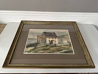 Framed watercolor painting showing entire artwork with mat and frame, depicting east coast houses near water.