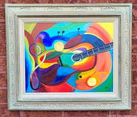 Framed colorful abstract oil painting showing guitar shapes and musical notes.
