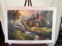 Full view of the lithograph showing a log cabin beside a creek with waterfall, framed by trees and a colorful sky