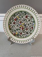 Front view of the Royal Doulton Parisian reticulated plate showing colorful birds and floral pattern with green border on white ceramic and scalloped edge