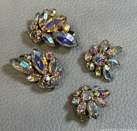 Two pairs of vintage Sherman clip-on earrings showing crystal settings and gold-tone metal backing.
