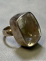 Close-up angled view of the vintage Charles Albert sterling silver ring showing the large faceted rectangular crystal and textured silver band.