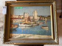 Full view of framed art print showing the harbor scene with several sailboats and buildings including two stone towers in the background.