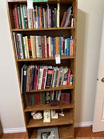 Full view of wooden bookshelf with mixed books and bookends visible