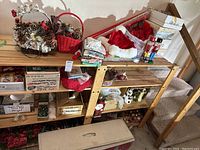 Overview showing the Christmas tree parts, baskets with pine cones, Santa hats, and various holiday decorations arranged on and under shelves.
