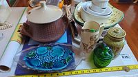 Various kitchenware including covered casserole, decorative trays, jugs, and glass items