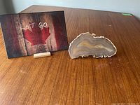 Photo showing the entire agate slice next to a Lot 60 card on a wood table surface.