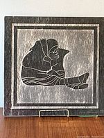 Front view of the two toned marble bas relief stone carving showing an Inuit mother and child, signed by artist David Bernett.