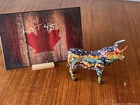 Mosaic bull figurine shown next to a lot number card for scale, displaying colorful mosaic pattern and design details on the side.