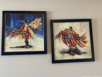 Two framed Native American dancer prints side by side showing full artwork in blue and gold-trimmed frames.