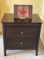 Chocolate brown night table with two drawers displayed against cream wall and carpet, showing front full view