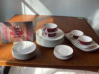 Complete set of Rosenthal china with cups stacked on luncheon plates and various plates arranged on table with sign showing lot title