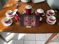 Complete coffee and tea set with cups and saucers arranged on table with label sign