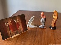 Three sculptures shown together with a lot sign in background